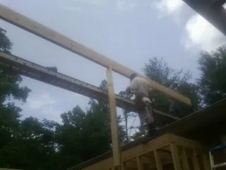 Carpenter setting a ridge beam over a new addition frame — Ice Dam Removal by Roofing Brothers in Estillfork