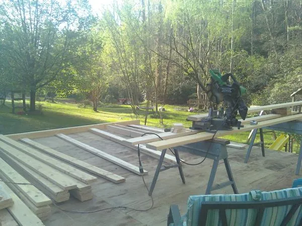 Miter saw and framing lumber on a deck under construction in Estillfork