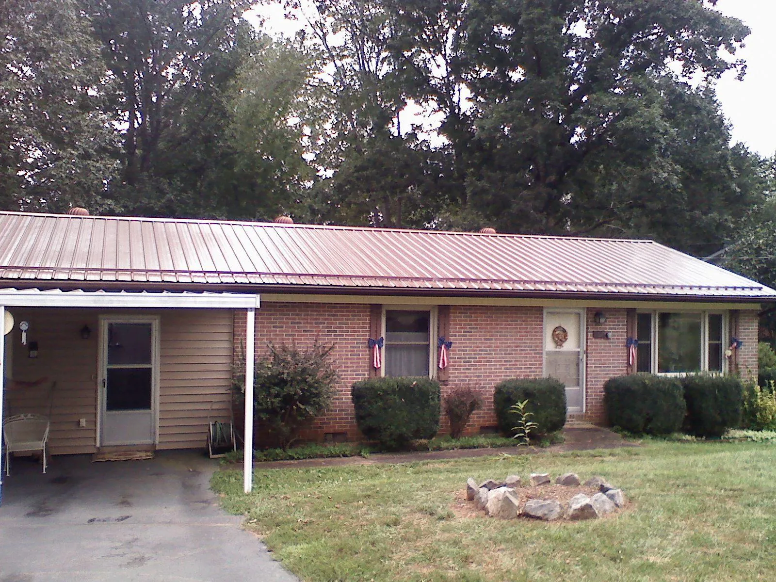 Bronze metal roof and carport on a brick ranch home — Roof Repair work by our crew in Estillfork
